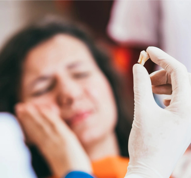 Woman with dental pain holding cheek, dentist wearing white glove examining tooth.