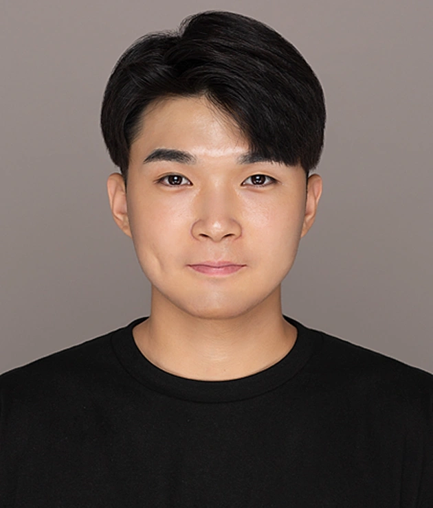 Young man in black shirt against neutral gray background, professional headshot style portrait.